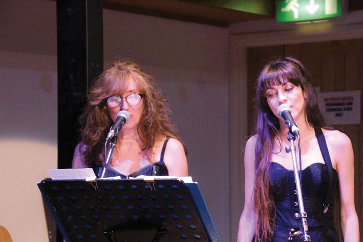 Sharon-&-Eleanore-doing-backing-vocals-for-students-at-one-of-the-Cranleigh-Community-Choir-concerts-website