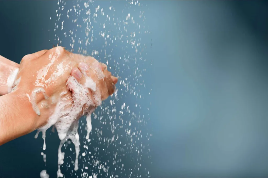 Man washing hands in clean water on blue background
