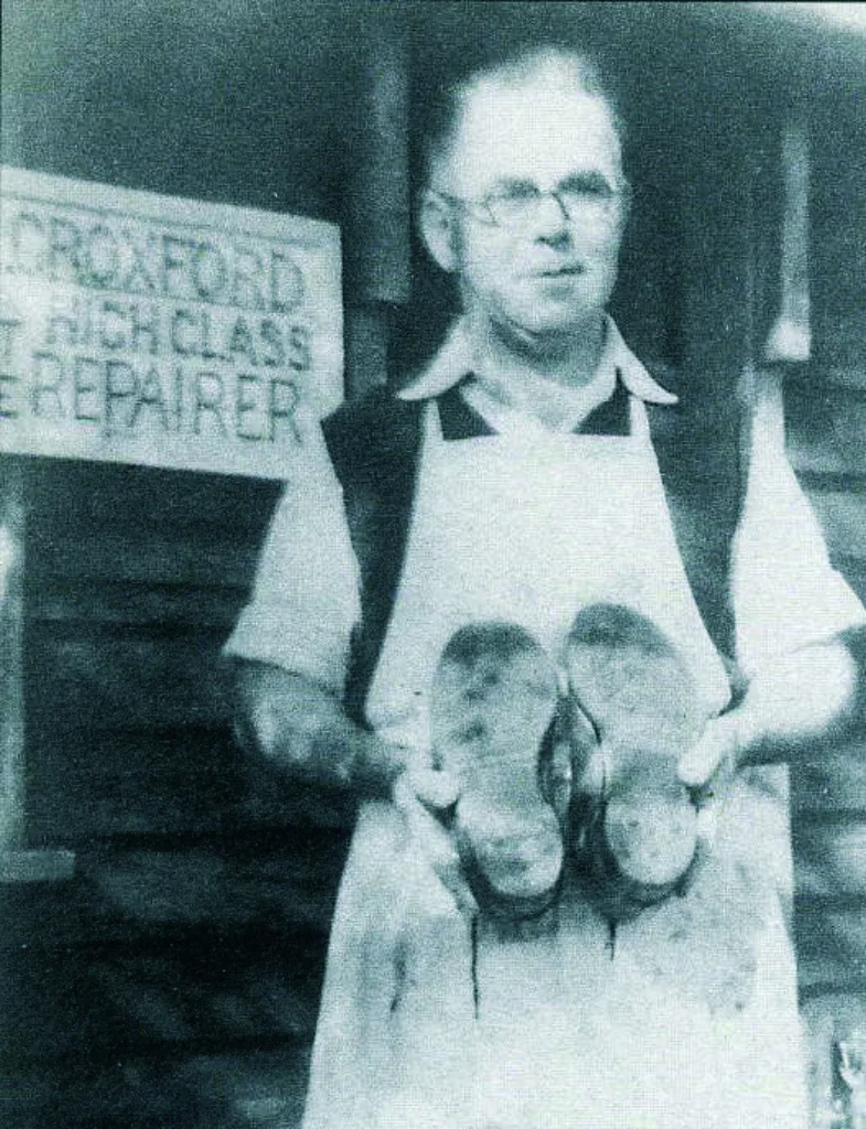 Charles H. Croxford (189 1977) outside his shop