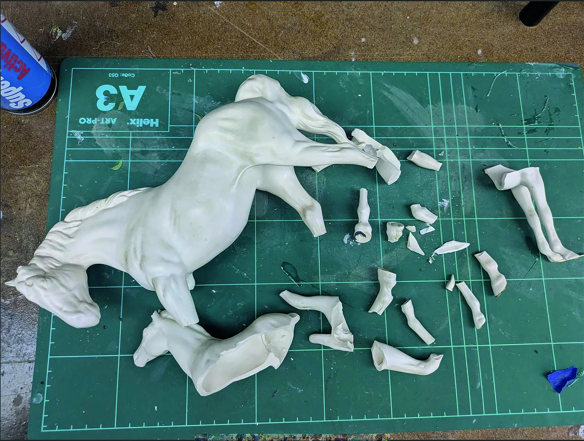 A broken ceramic horse in many pieces before repair