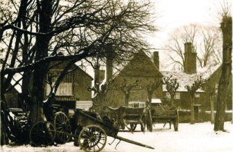 The Cranleigh wheelwright's working yard around 1900, with wagons, a cart and spare wheels in front of the workshop.