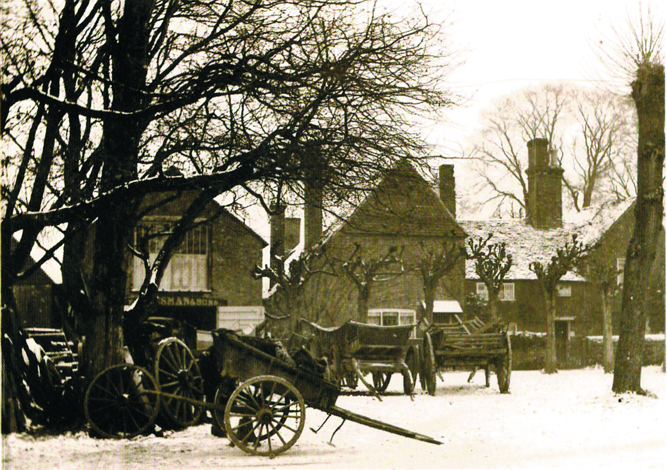 The Cranleigh wheelwright's working yard around 1900, with wagons, a cart and spare wheels in front of the workshop.