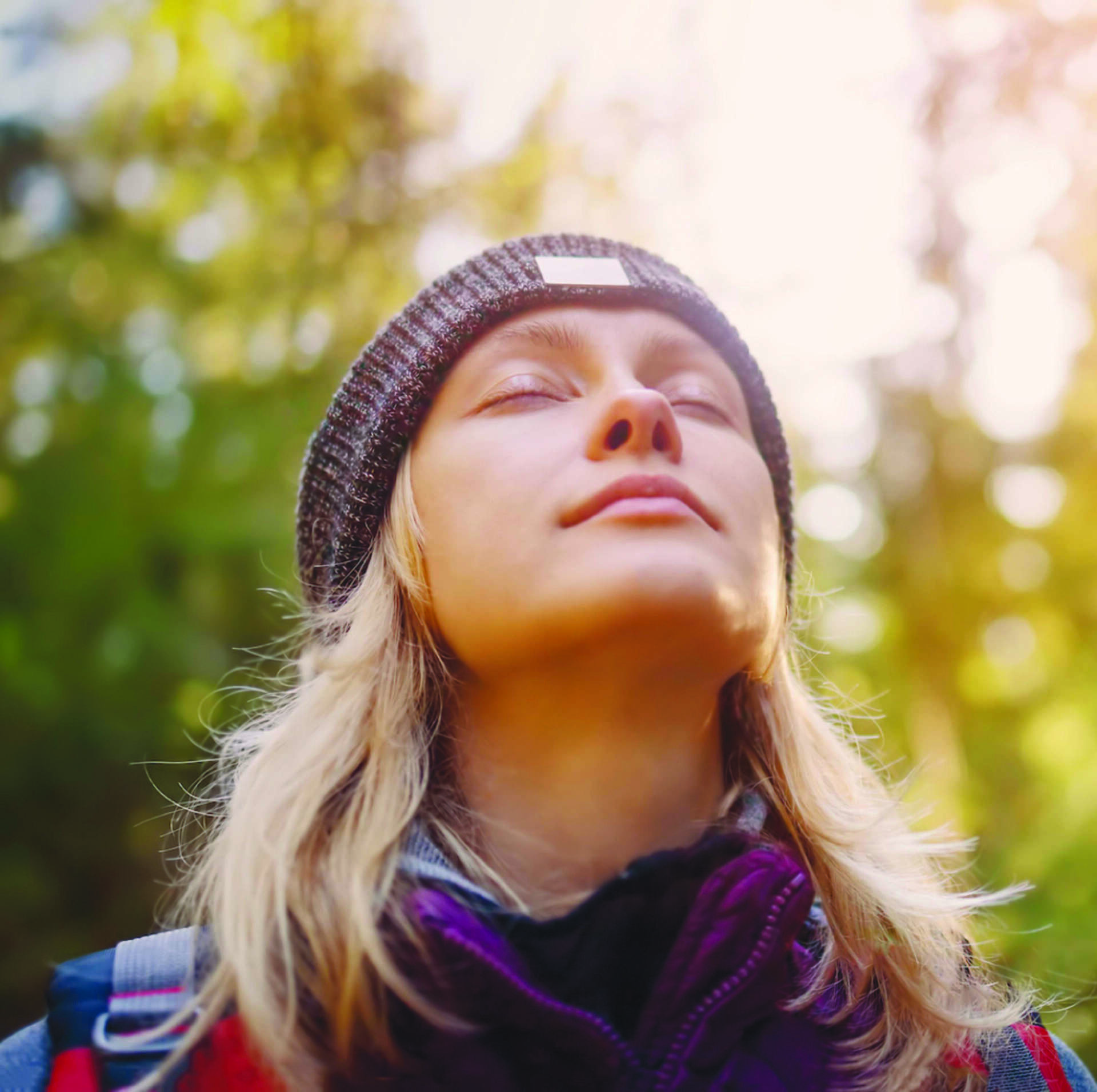 A woman breathing calmly through her nose, face turned up to the light