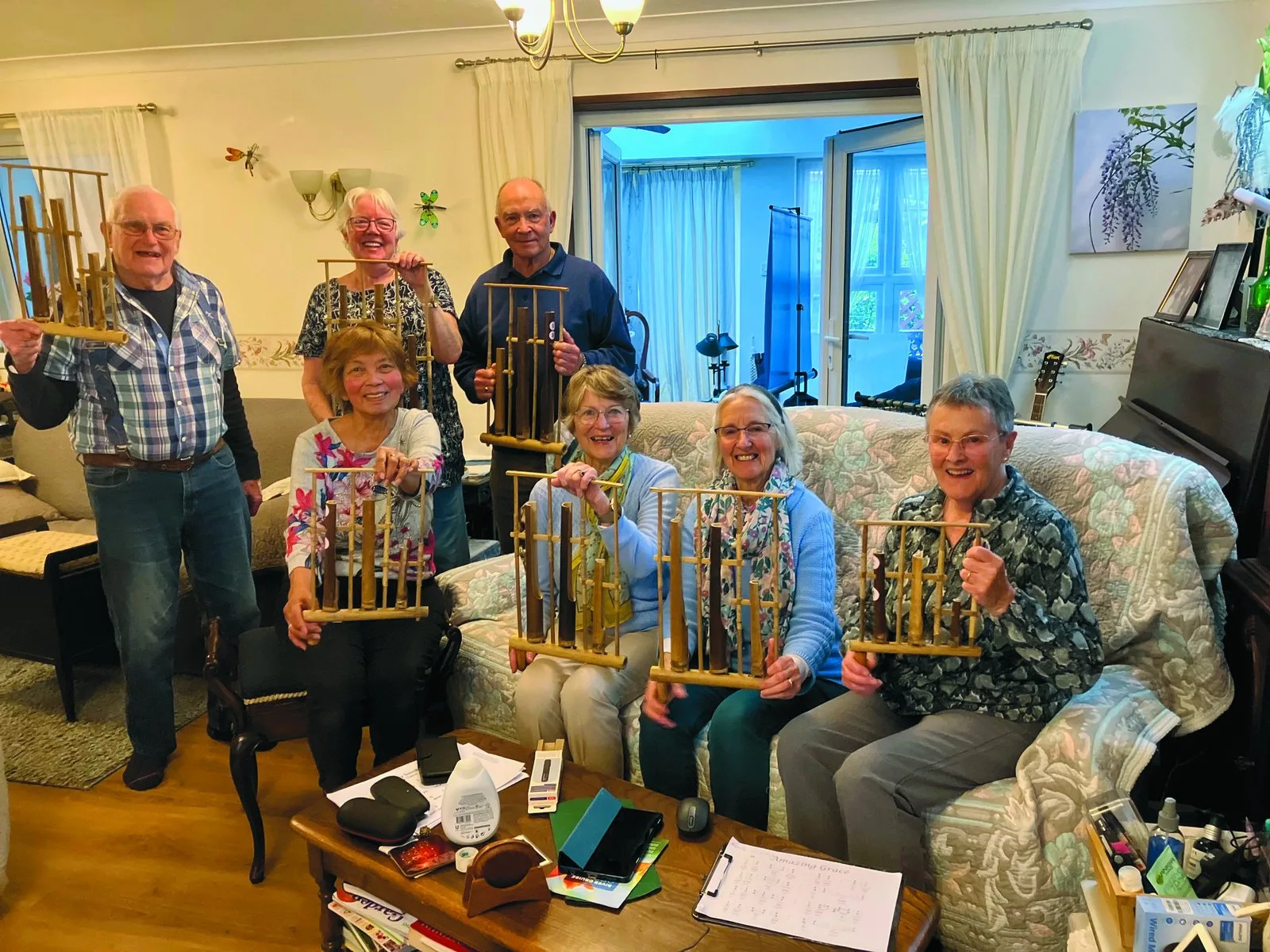 Members of the Memory Lane team smiling and holding bamboo angklung chimes