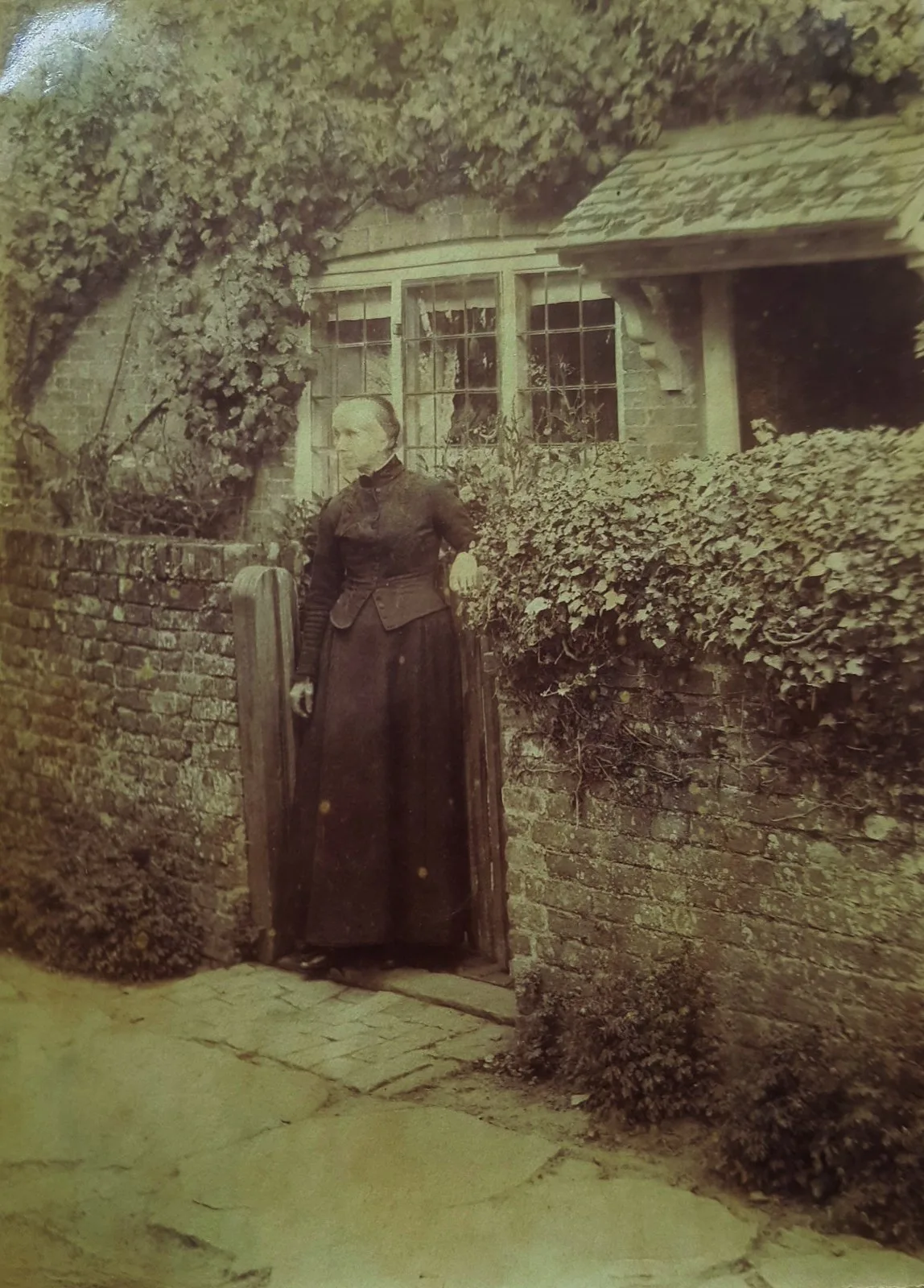 Esther Cheesman standing outside her cottage about 1900