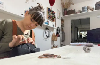 Virna Pasquinelli hand-stitching a hat in her studio