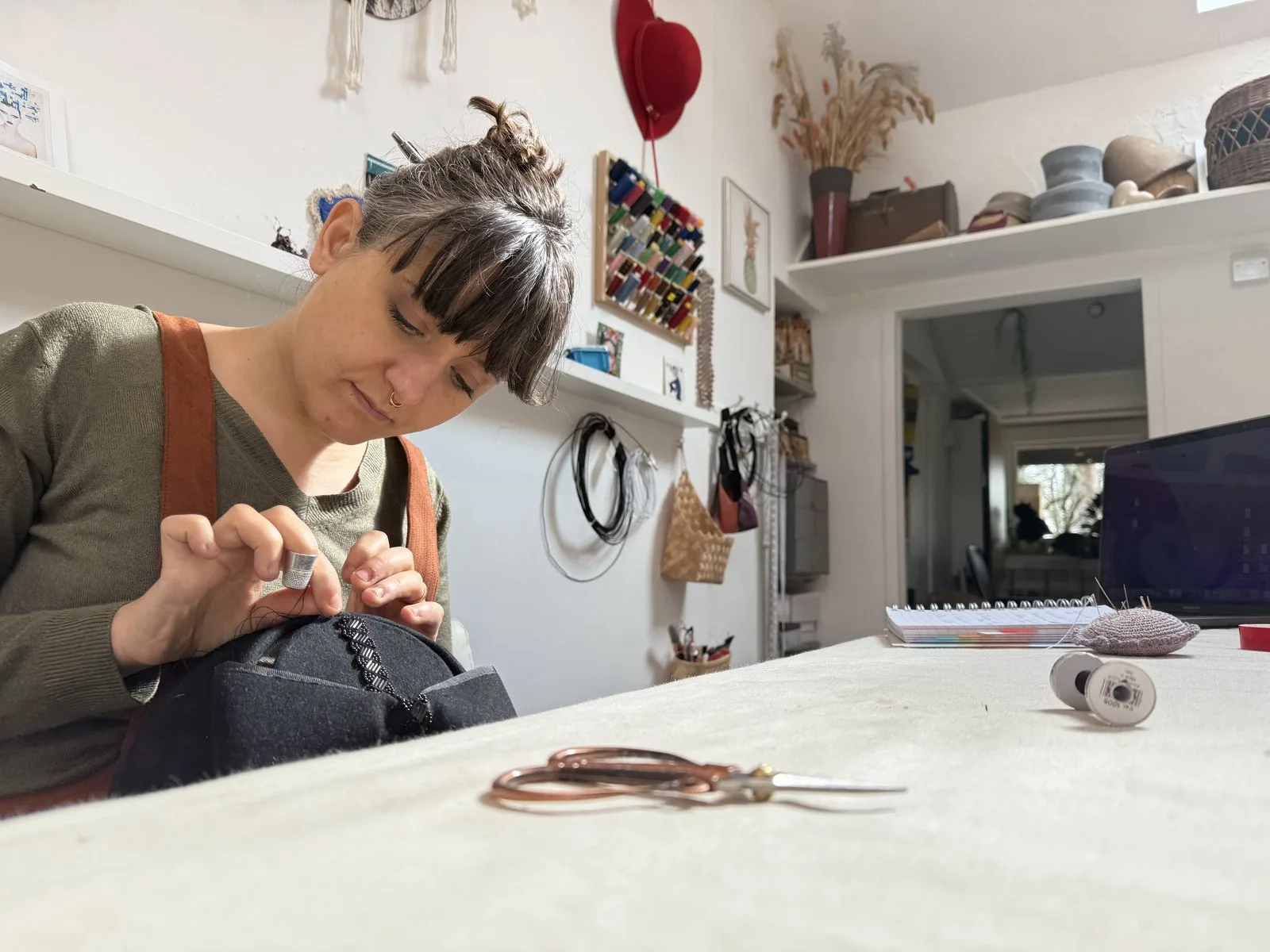 Virna Pasquinelli hand-stitching a hat in her studio