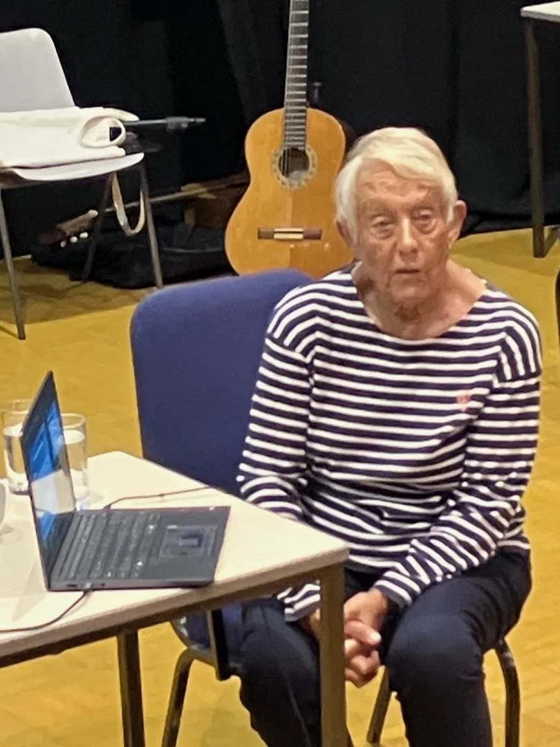 Dr Jill Rasmussen seated beside a laptop at the Memory Lane presentation in Cranleigh Arts Centre