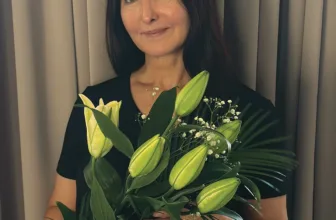 Maria Kovalikova holding a bouquet of white lilies