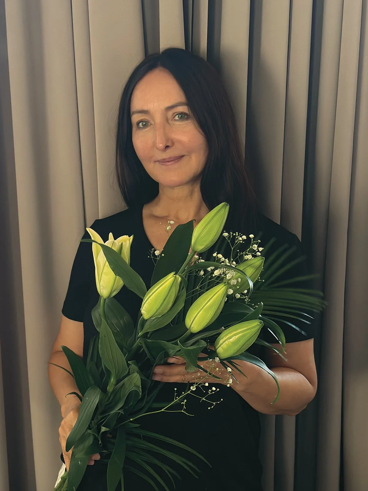 Maria Kovalikova holding a bouquet of white lilies