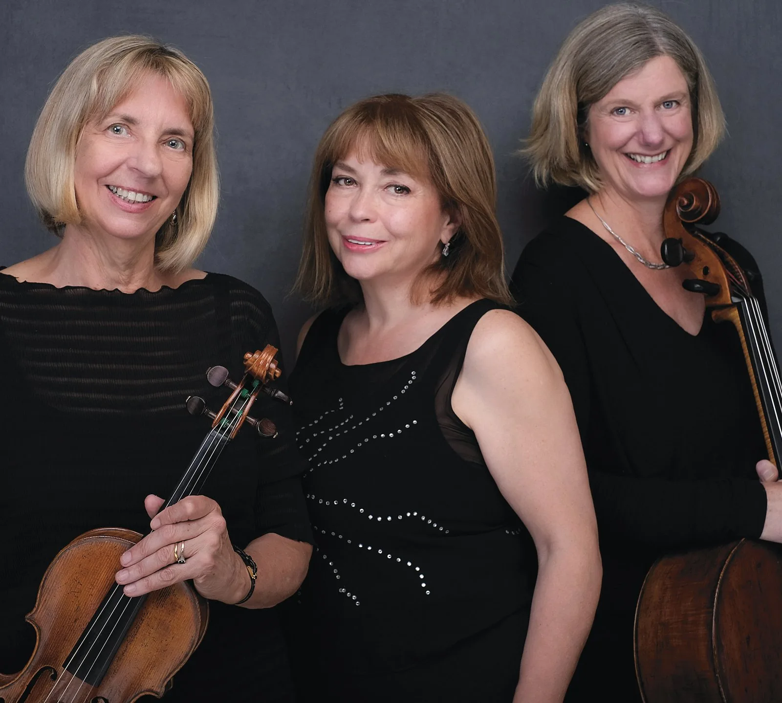 The three members of the Mordkovitch Trio, two of them holding a violin and a cello